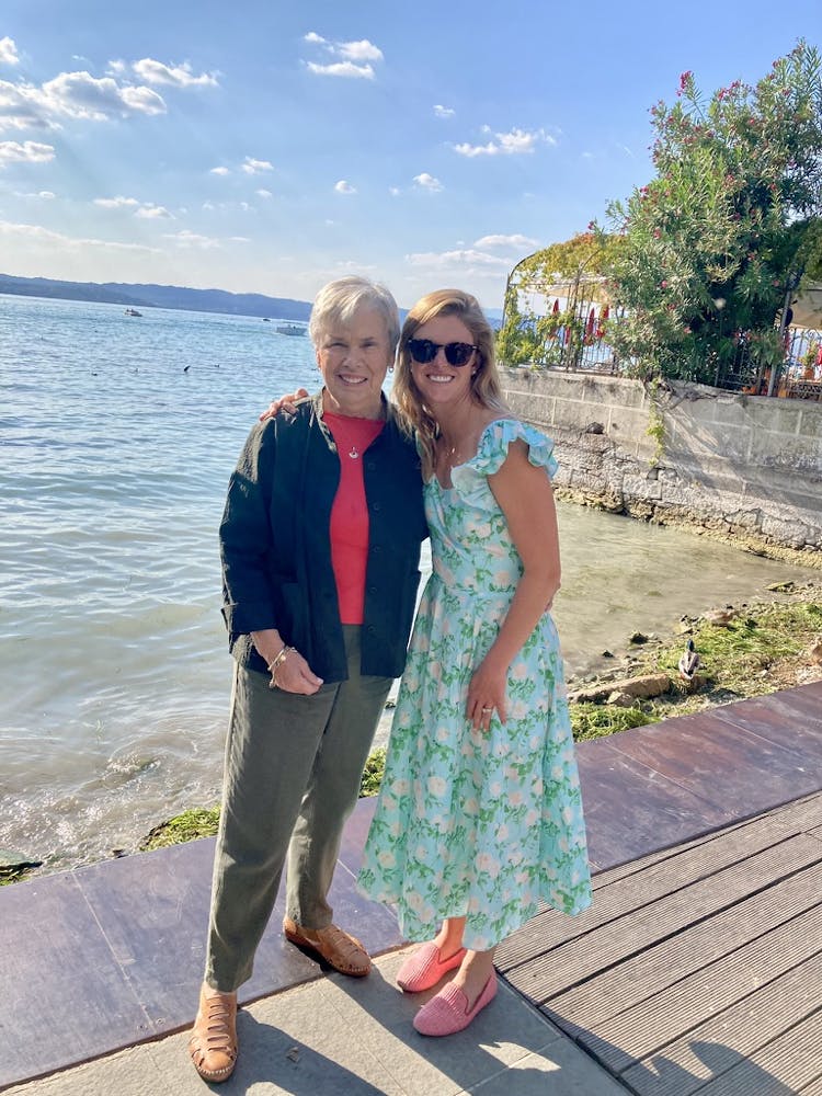 two women standing in front of water smiling