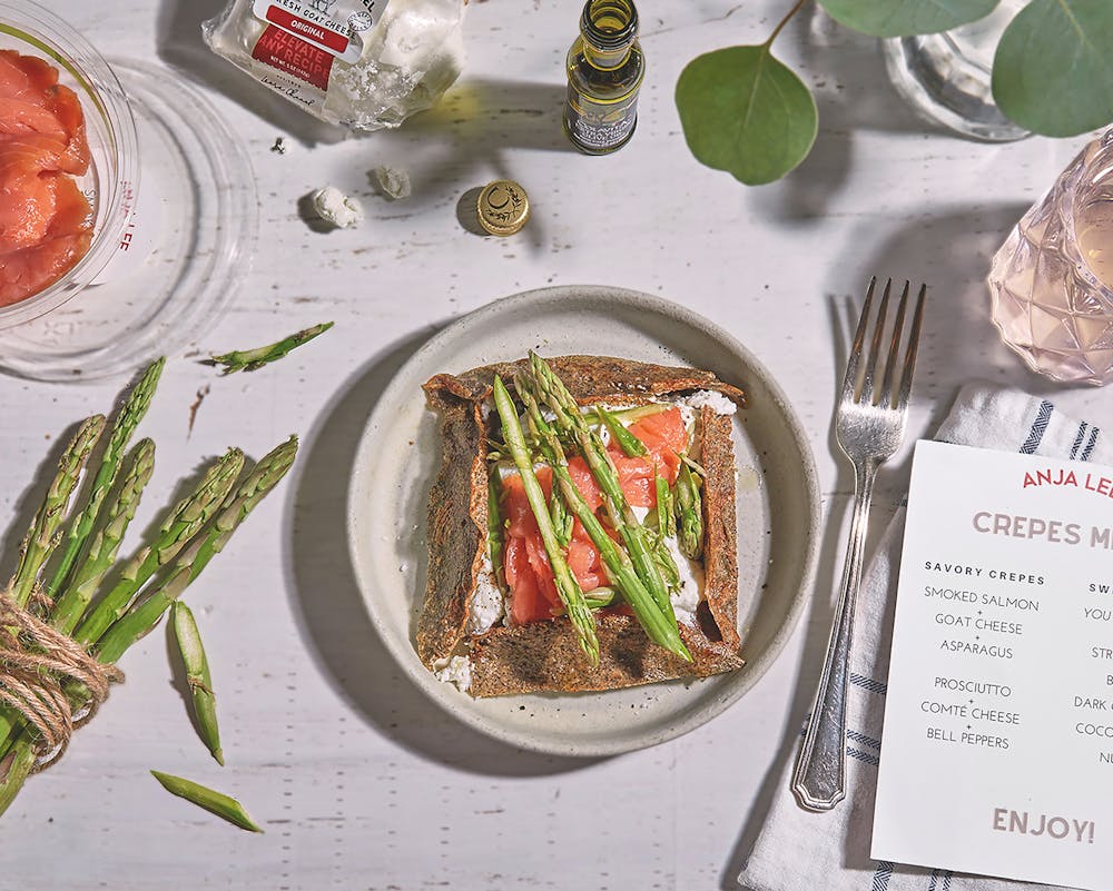 a plate of crepes with salmon and asparagus