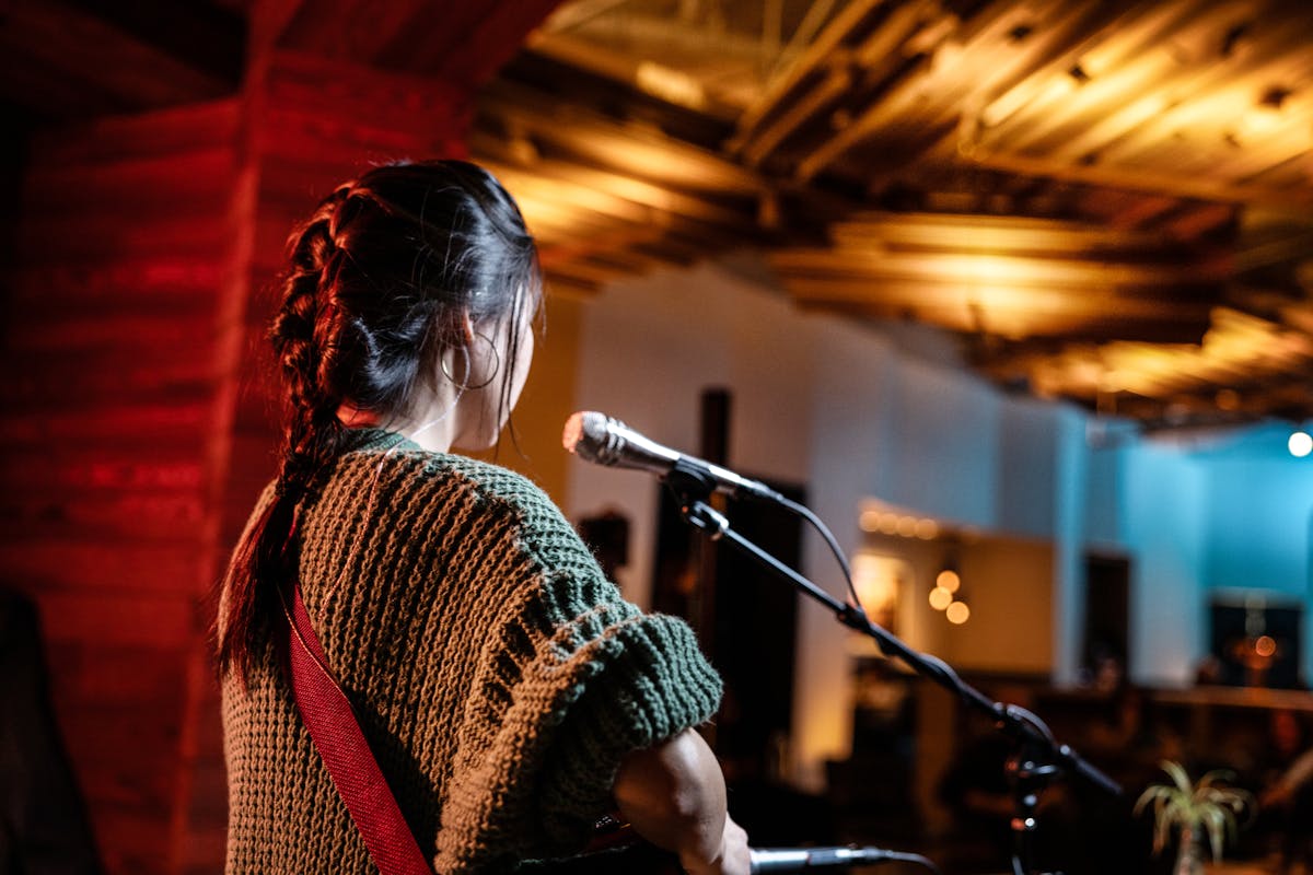female musician singing in front of a restaurant crowd