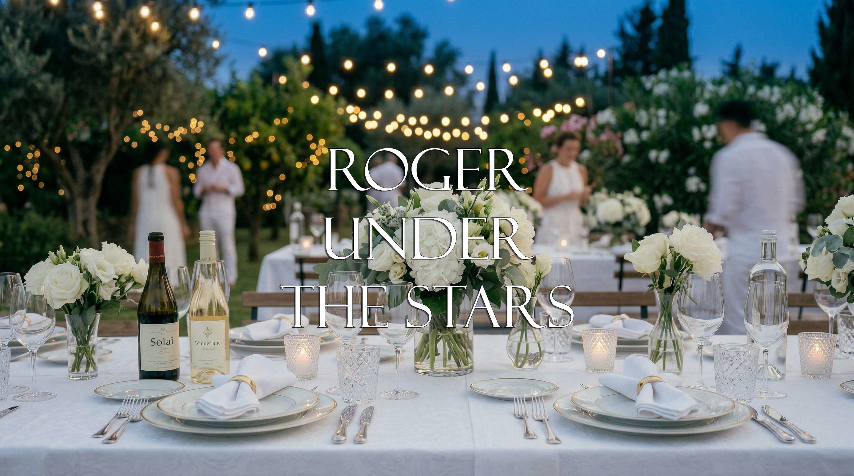 Image of a dining setup outside. White table lines and elegant setup with greenery and string lights in the back. Some people dressed in white scattered around.