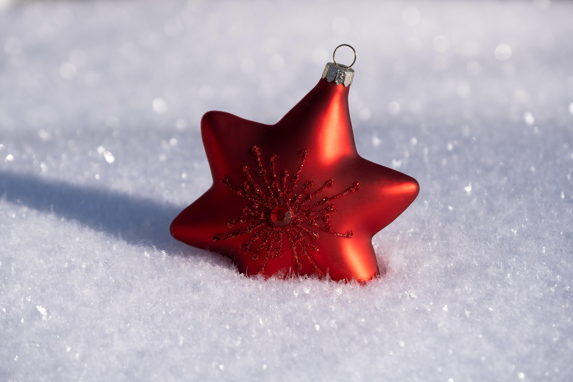 a small red decorative star covered halfway in snow