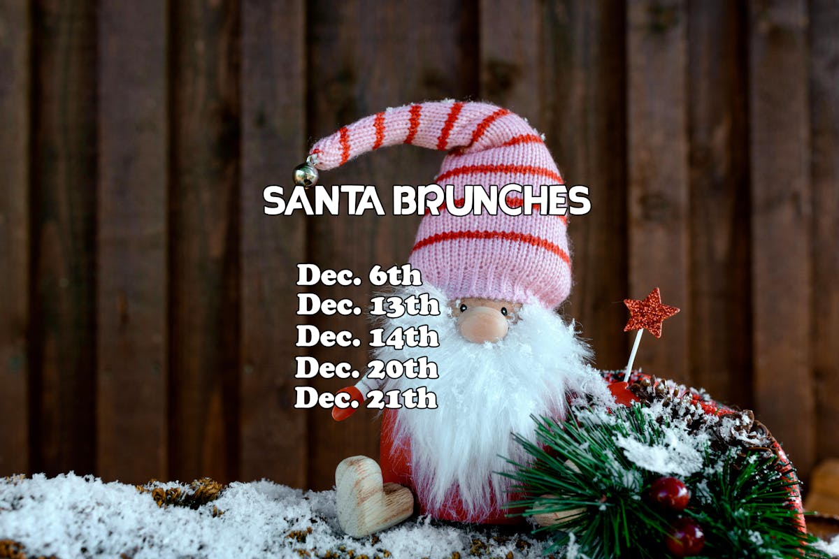 A small figurine dressed as Santa with beard, hat and snow