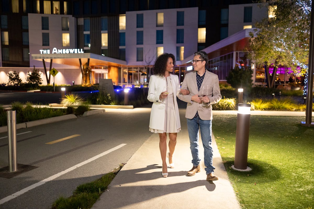 a couple walking in front of the Ameswell Hotel