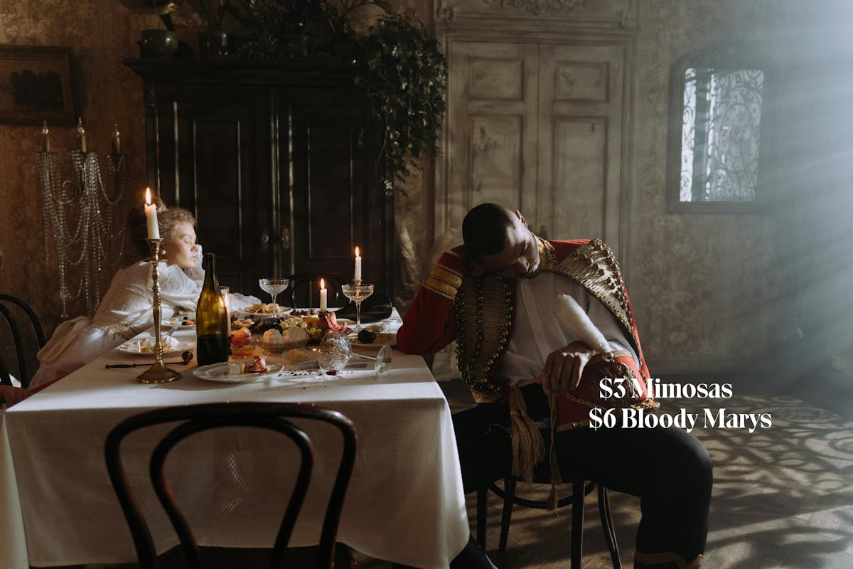 Two people hung over at a dinner table. This image is a period picture.