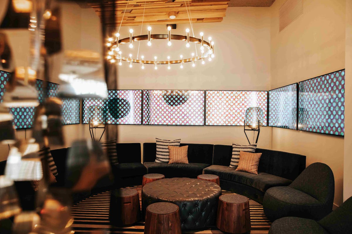 a comfortable area with chairs arranged in a circular pattern around a table and chandellier