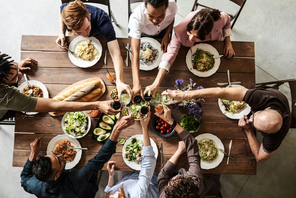 a group of people sitting at a table with food