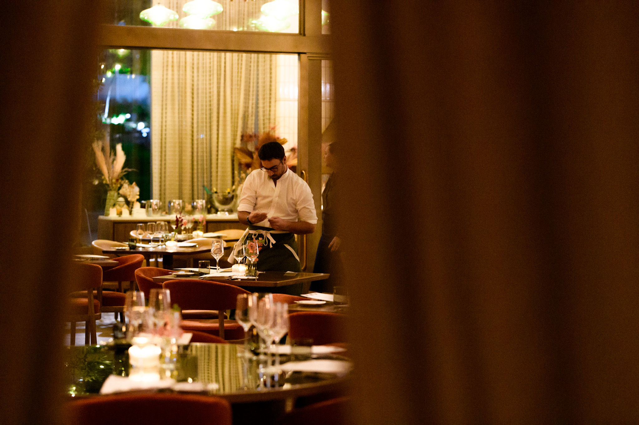 a man sitting at a table with wine glasses