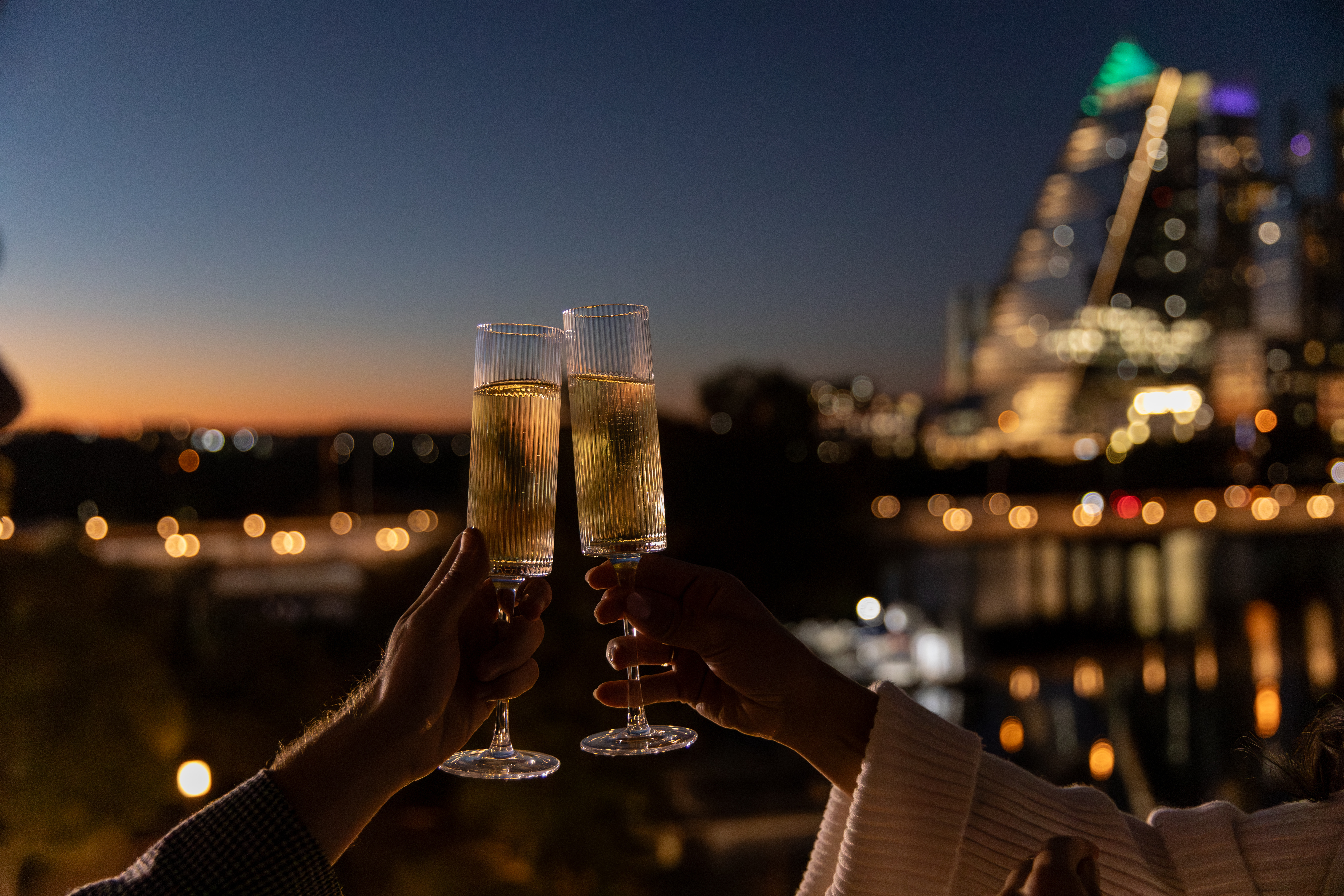 a pair of hands holding up champagne glasses