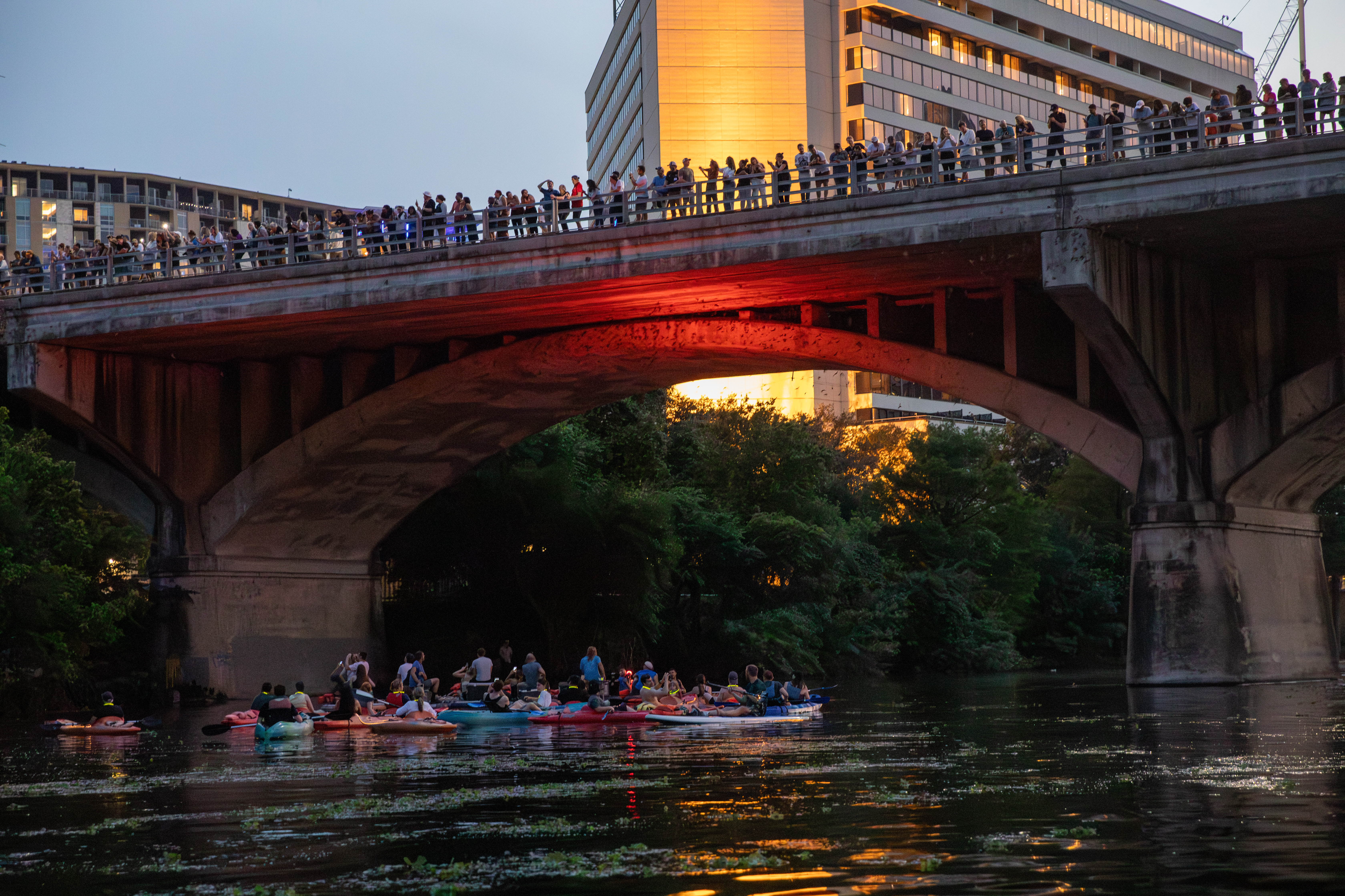 a group of people on rafts under a bridge