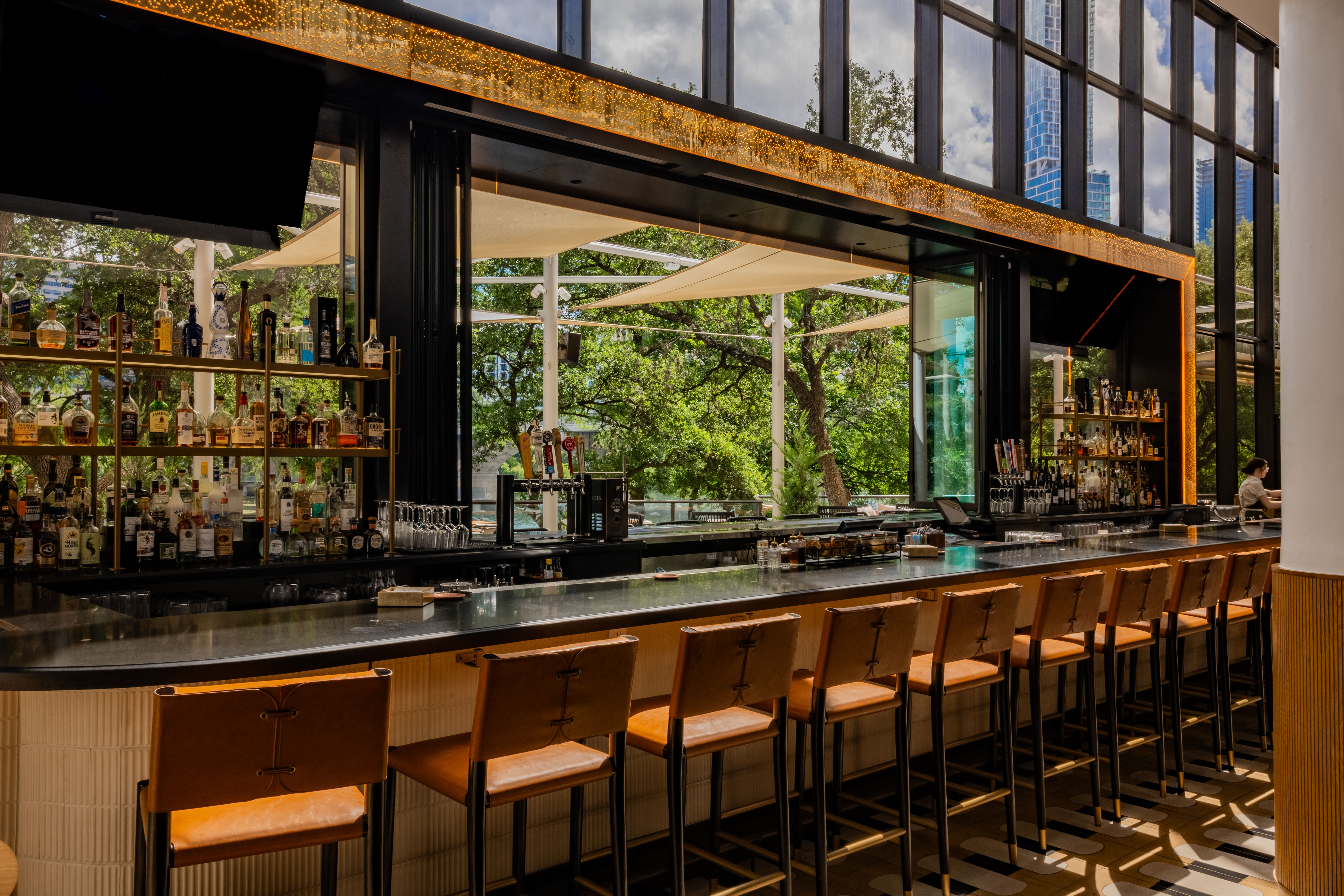 a bar with chairs and a large window