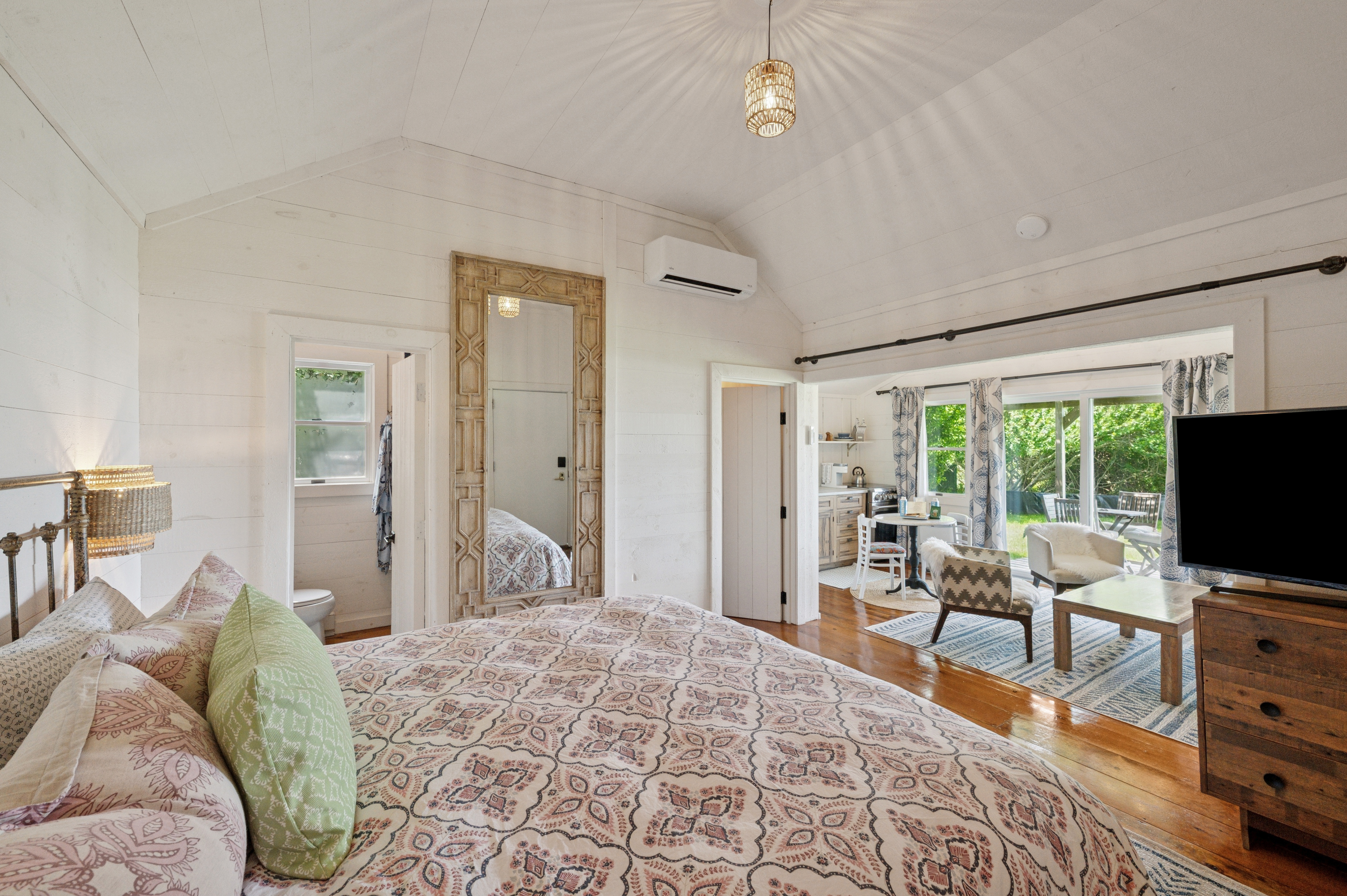 a bedroom with a large bed and a living room