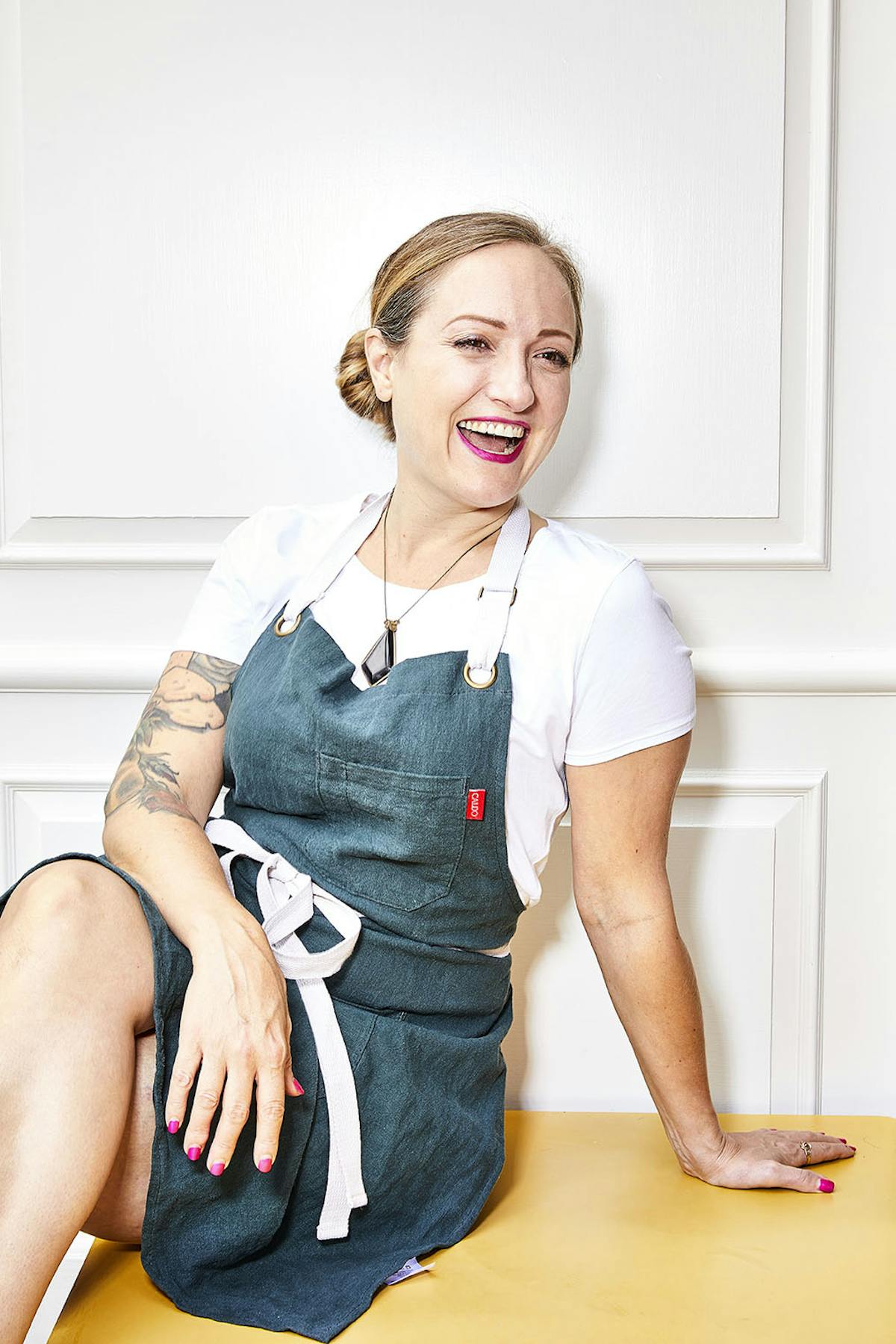 a woman sitting on a chair laughing at the camera