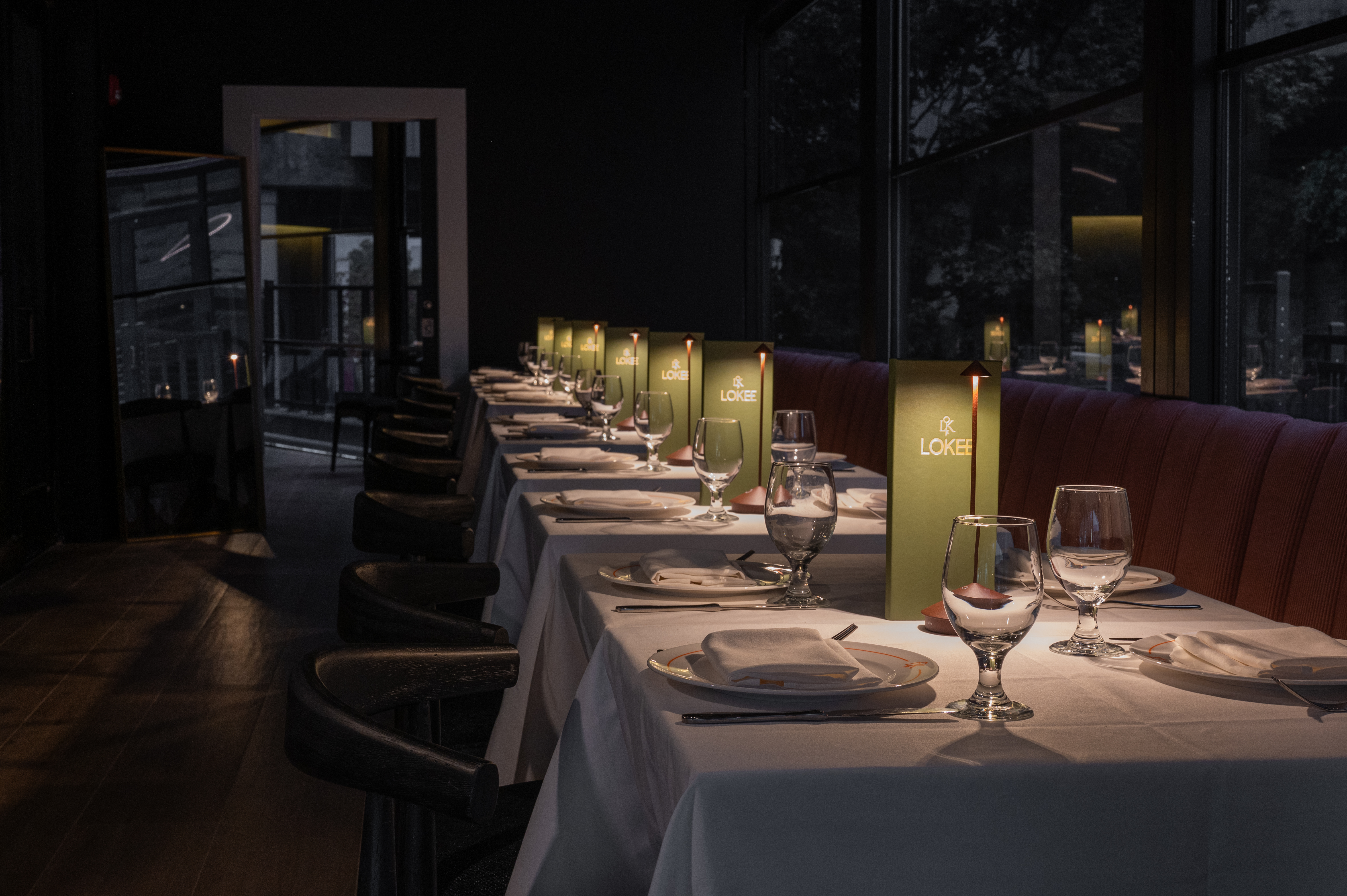 a long table with white tablecloths and plates with candles