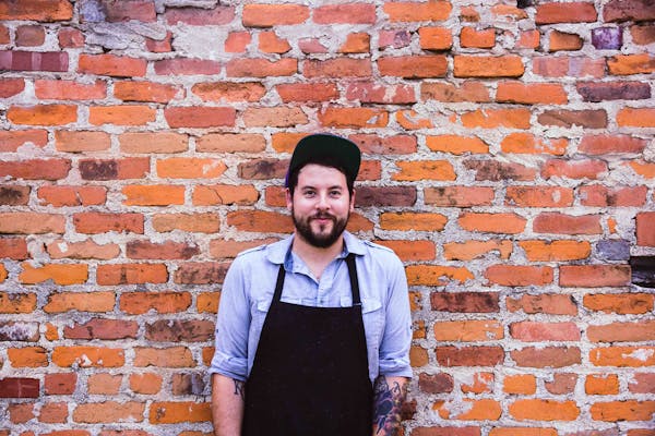 a person standing in front of a brick wall