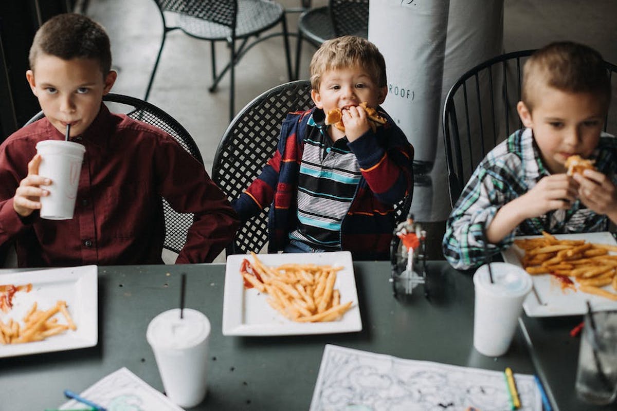 a young boy sitting at a table eating food