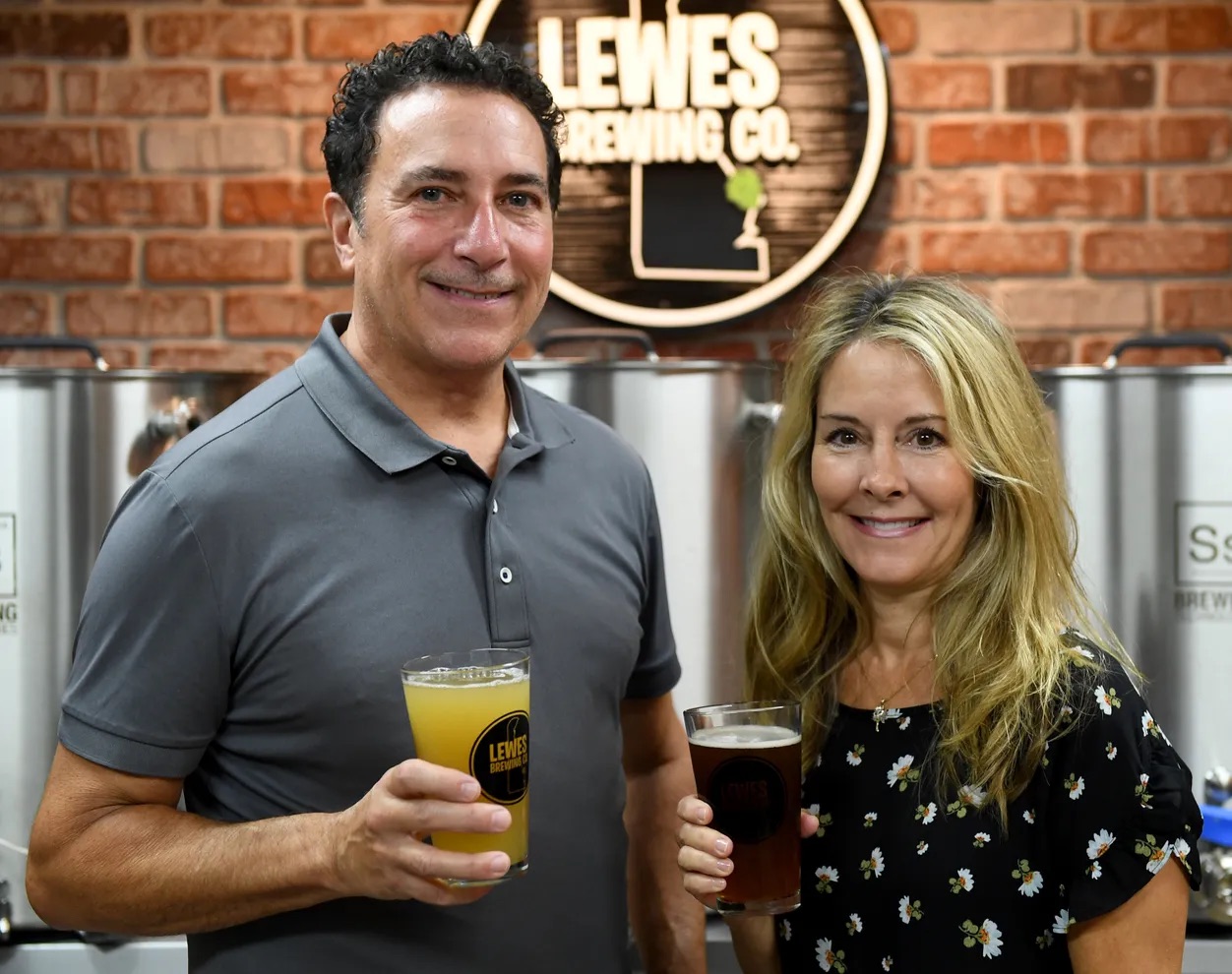 owners standing in front of sign