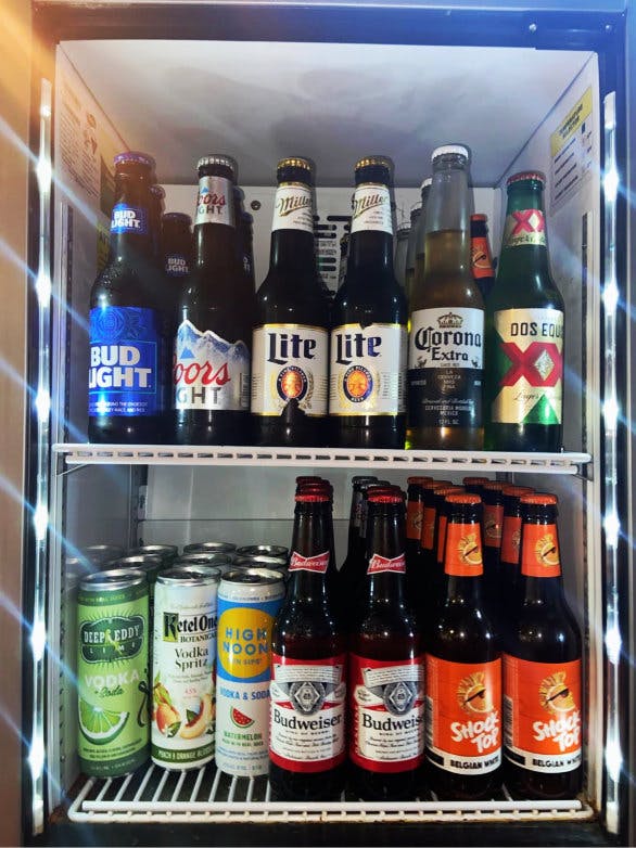 a bottle of beer next to a refrigerator