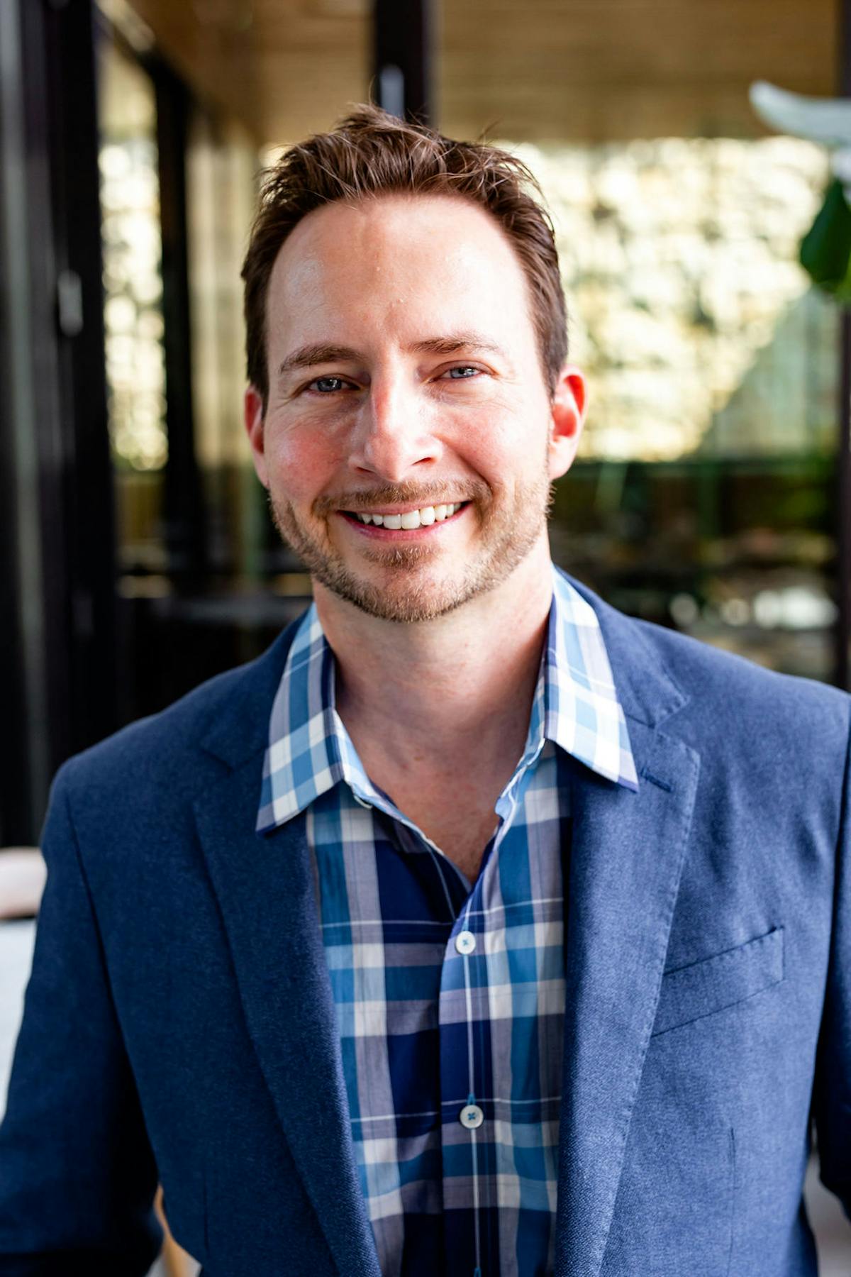 a man wearing glasses and smiling at the camera