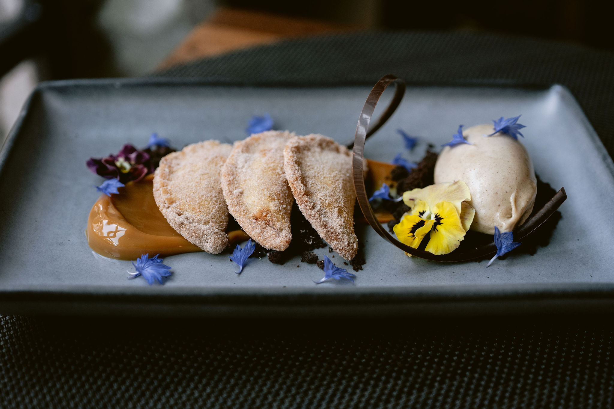 a plate of food with flowers and sauce