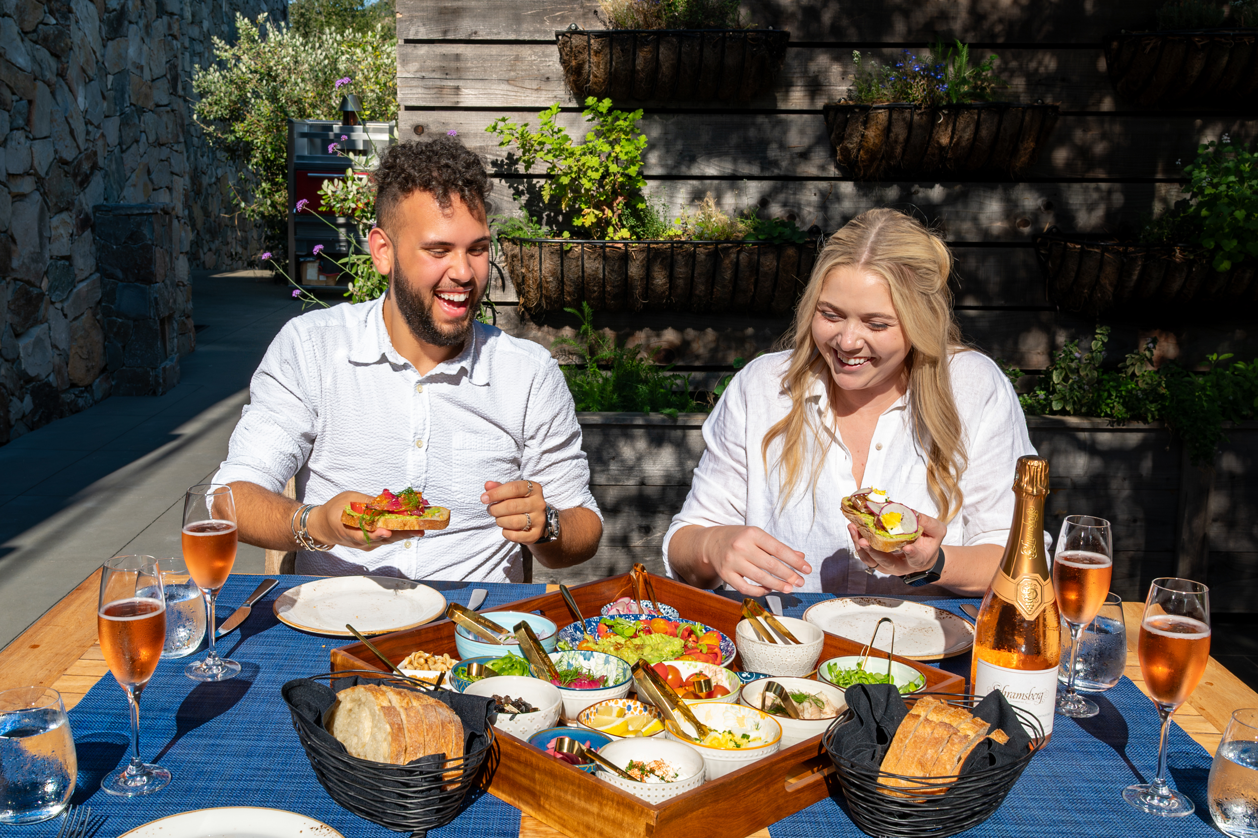 a man and woman sitting at a table with food