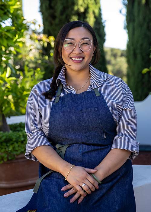 Chef Nini Nguyen wearing glasses and a striped shirt, hosting a pop-up dinner event at The Grove.