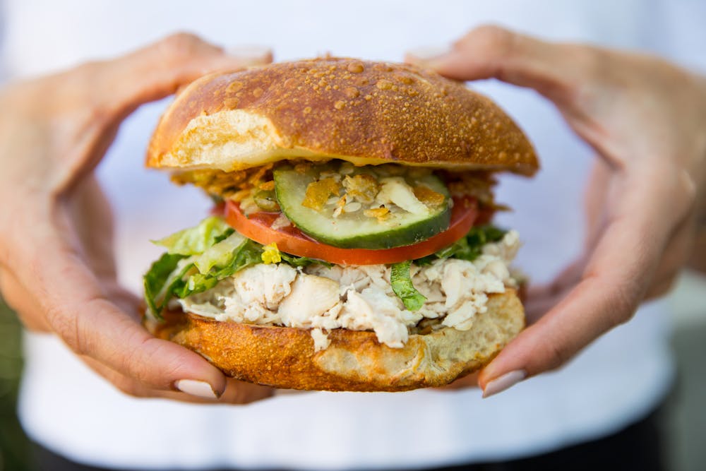 a hand holding a sandwich