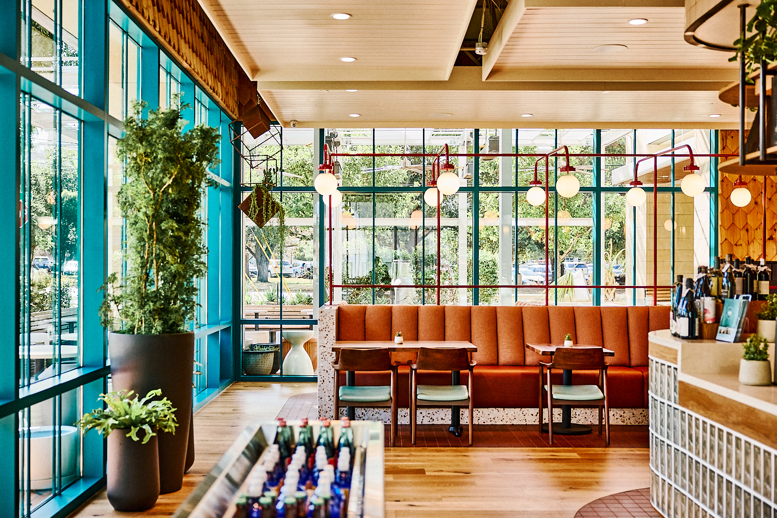 a room with a booth and tables and plants