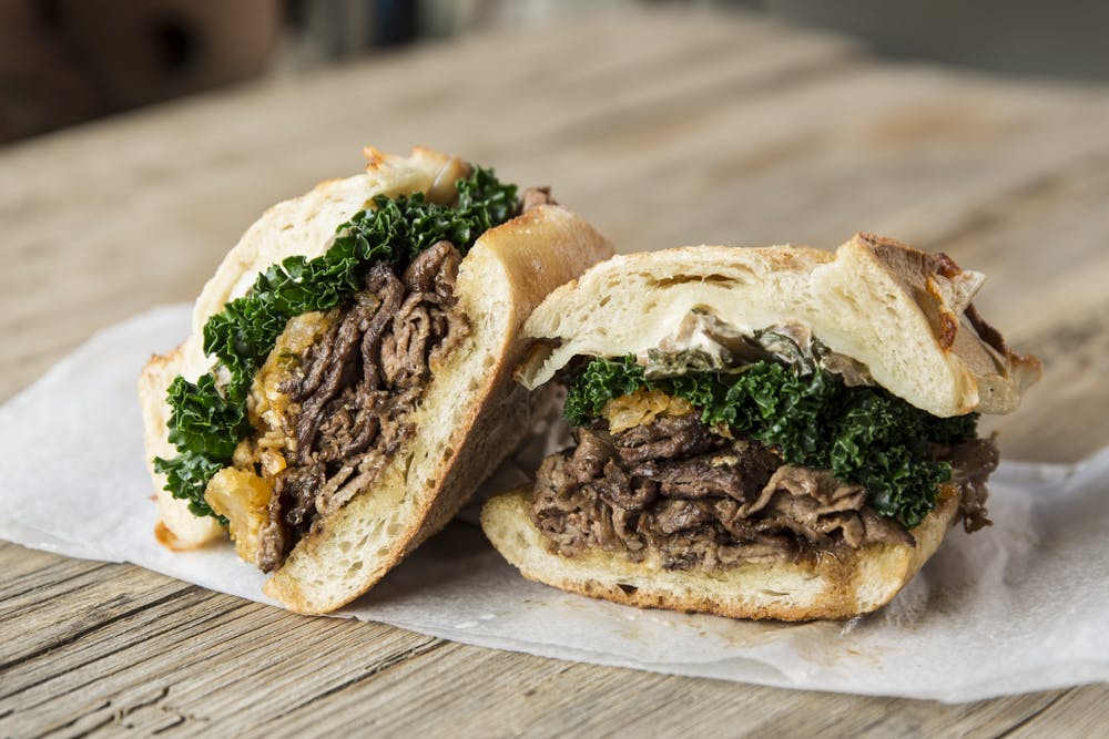 a half eaten sandwich sitting on top of a wooden table