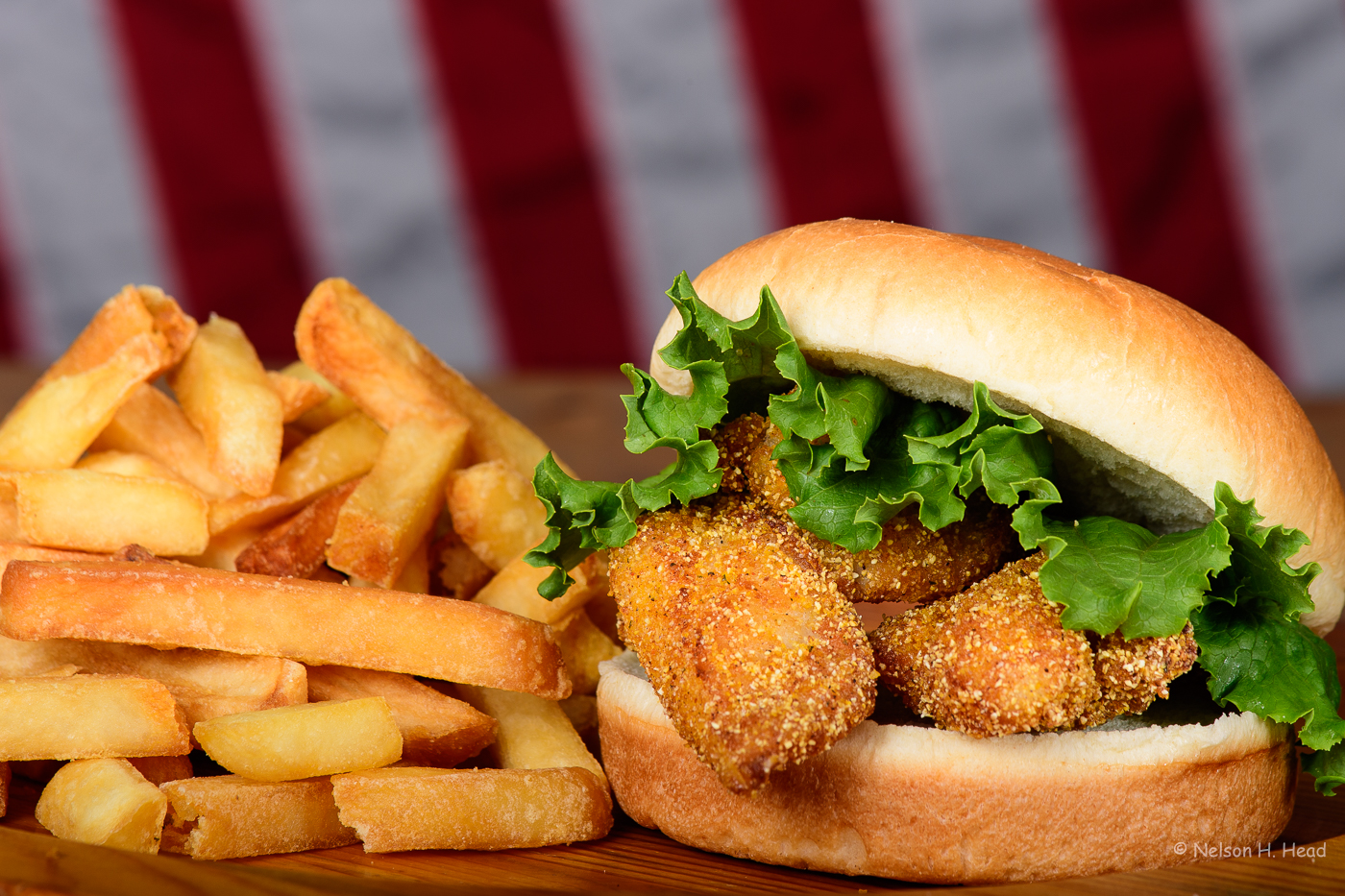 a close up of a sandwich sitting on top of a pile of fries