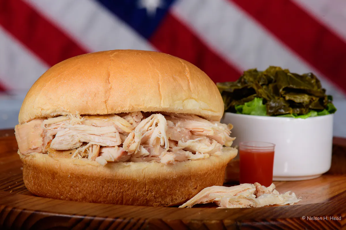 a sandwich with meat and a bowl of salad