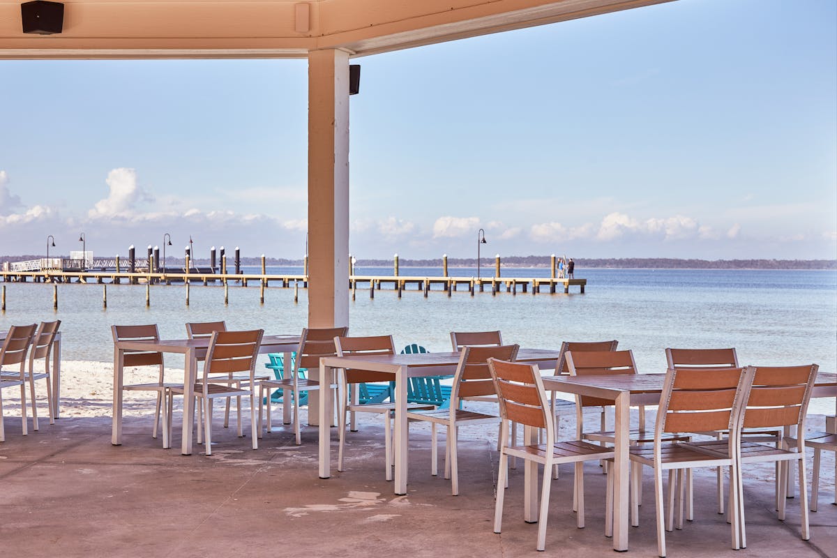 tables and chairs se up under a gazebo on the beach