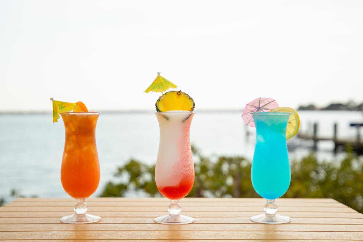 three cocktails with a view of the ocean