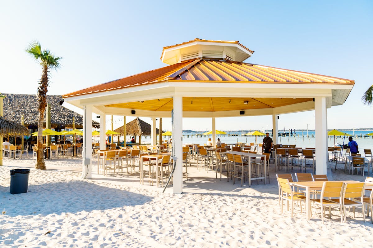a covered bar and patio on the beach