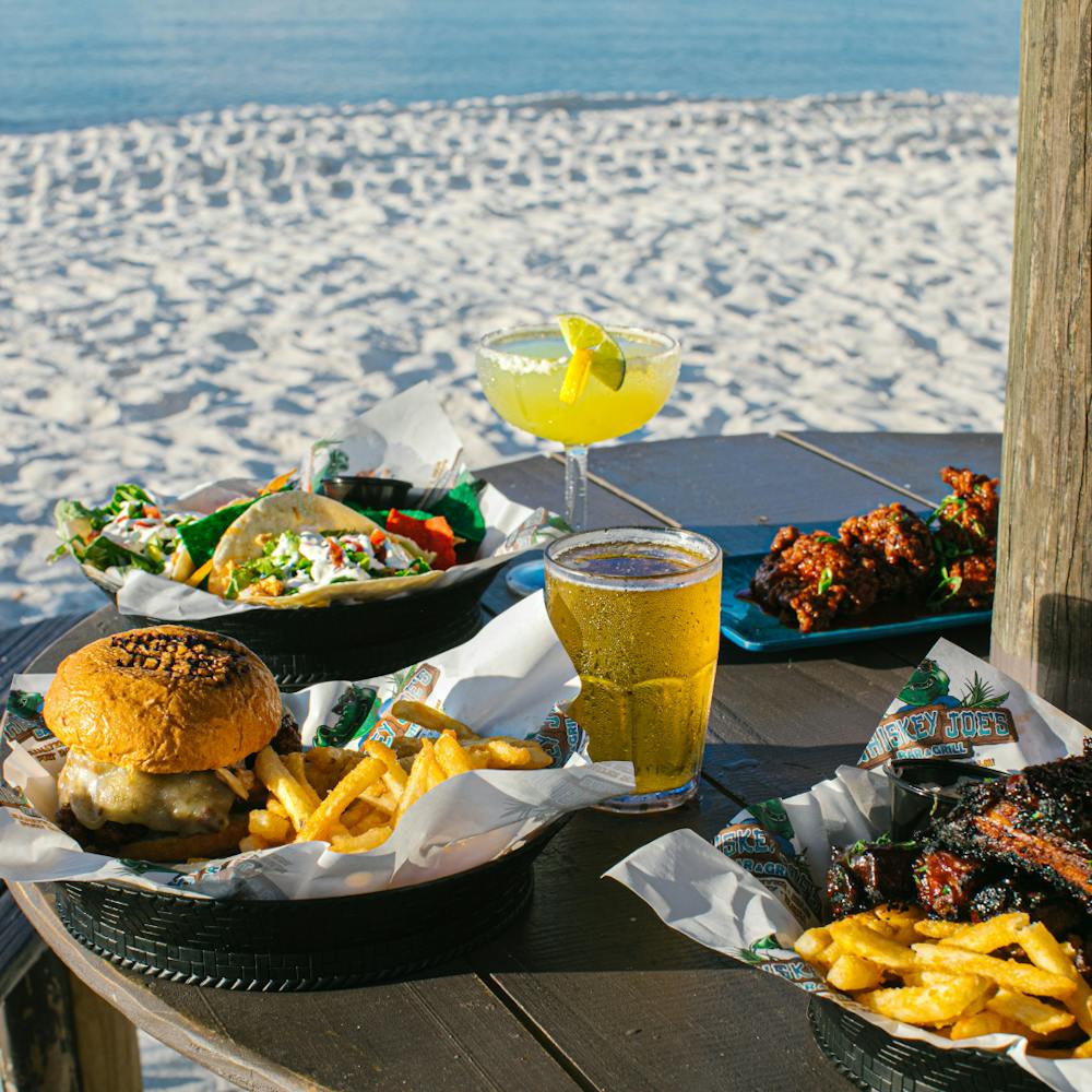 a woman sitting at a table with food and water