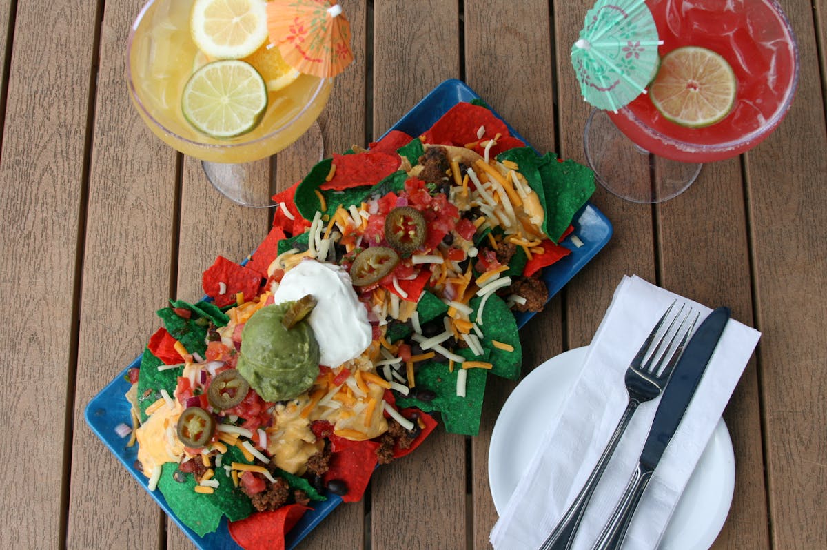 a plate of nachos on a wooden table