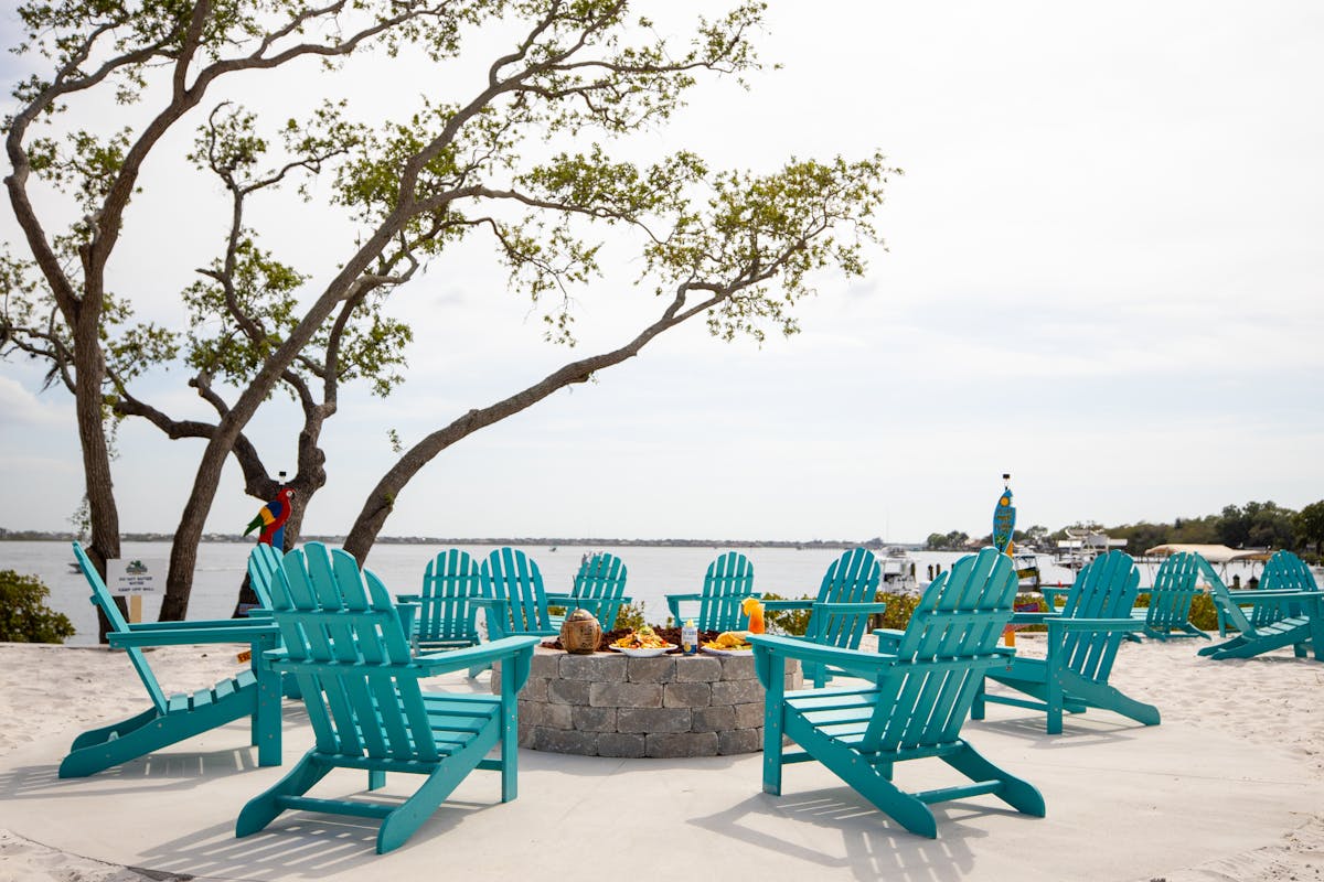 chairs around a fire pit on the beach