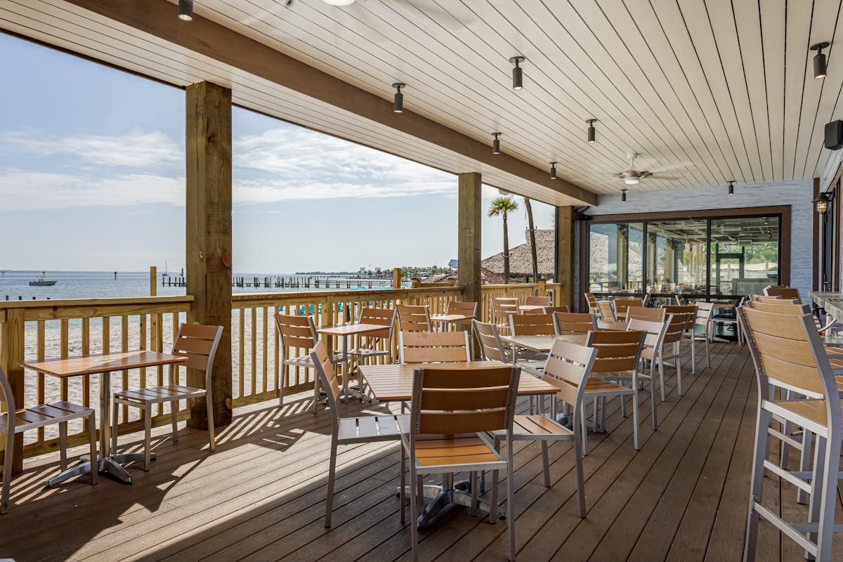 a covered patio with a view of the beach