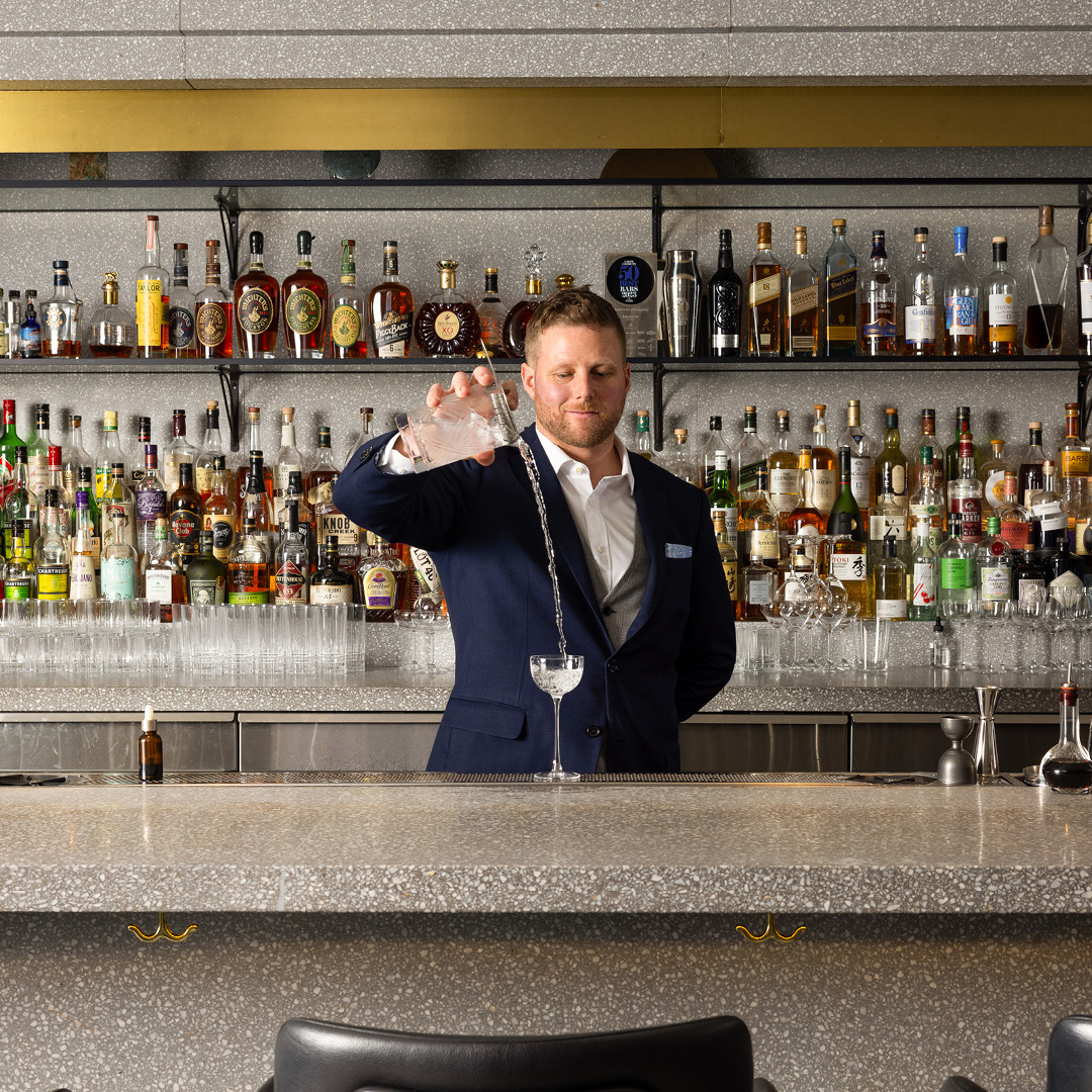 Grant Sceney standing next to a bottle of wine