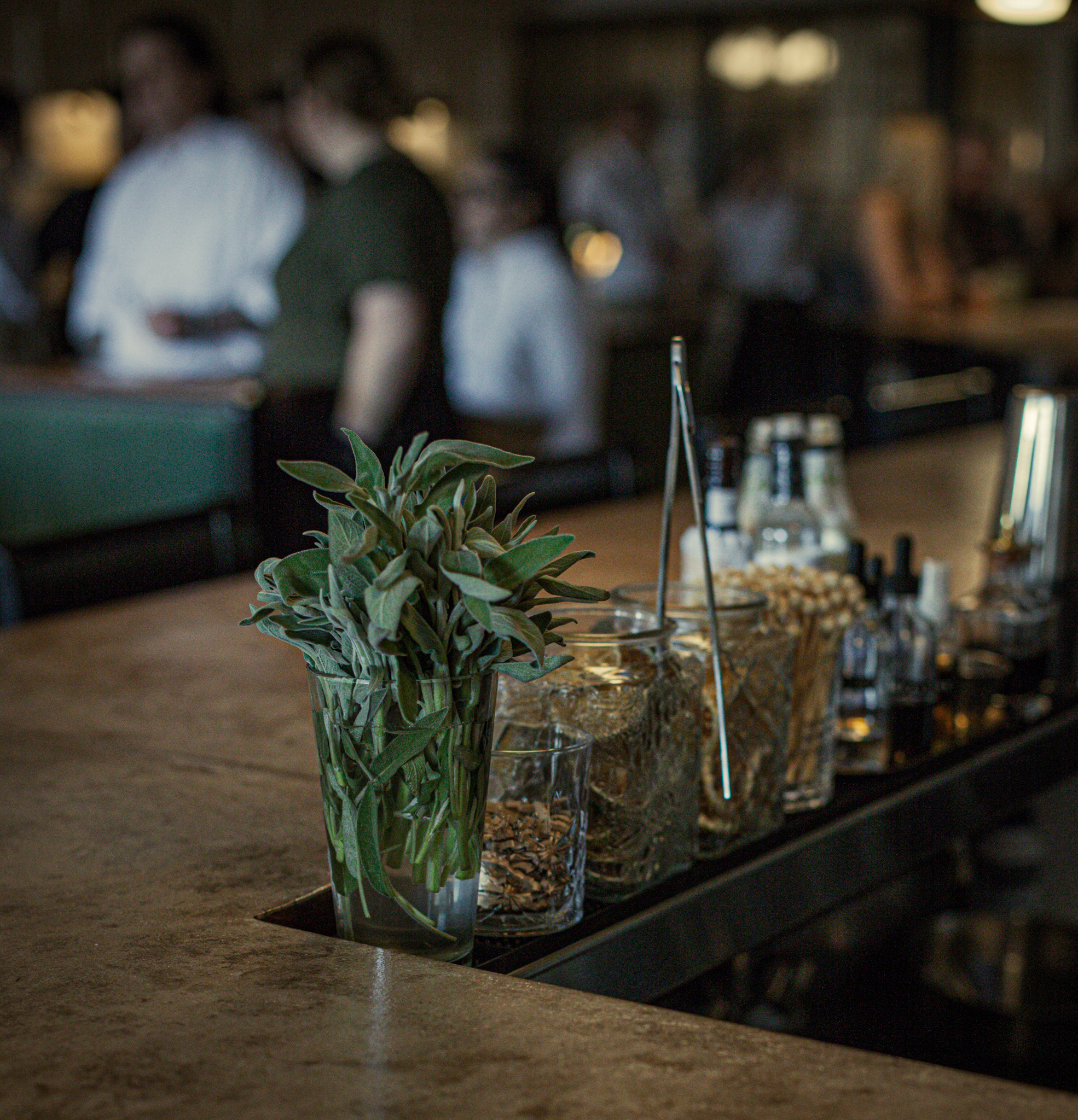 a table topped with drinks decorated with rosemary and mint