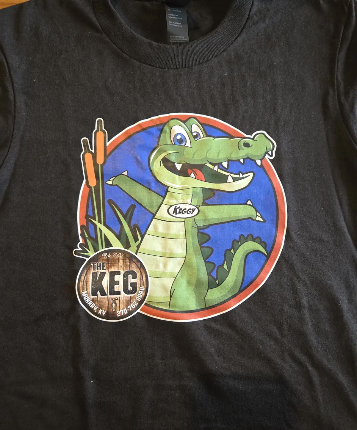 a black shirt with a cartoon alligator on it