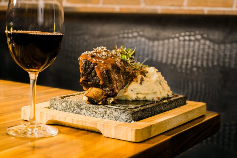 a glass of wine sitting on top of a wooden table