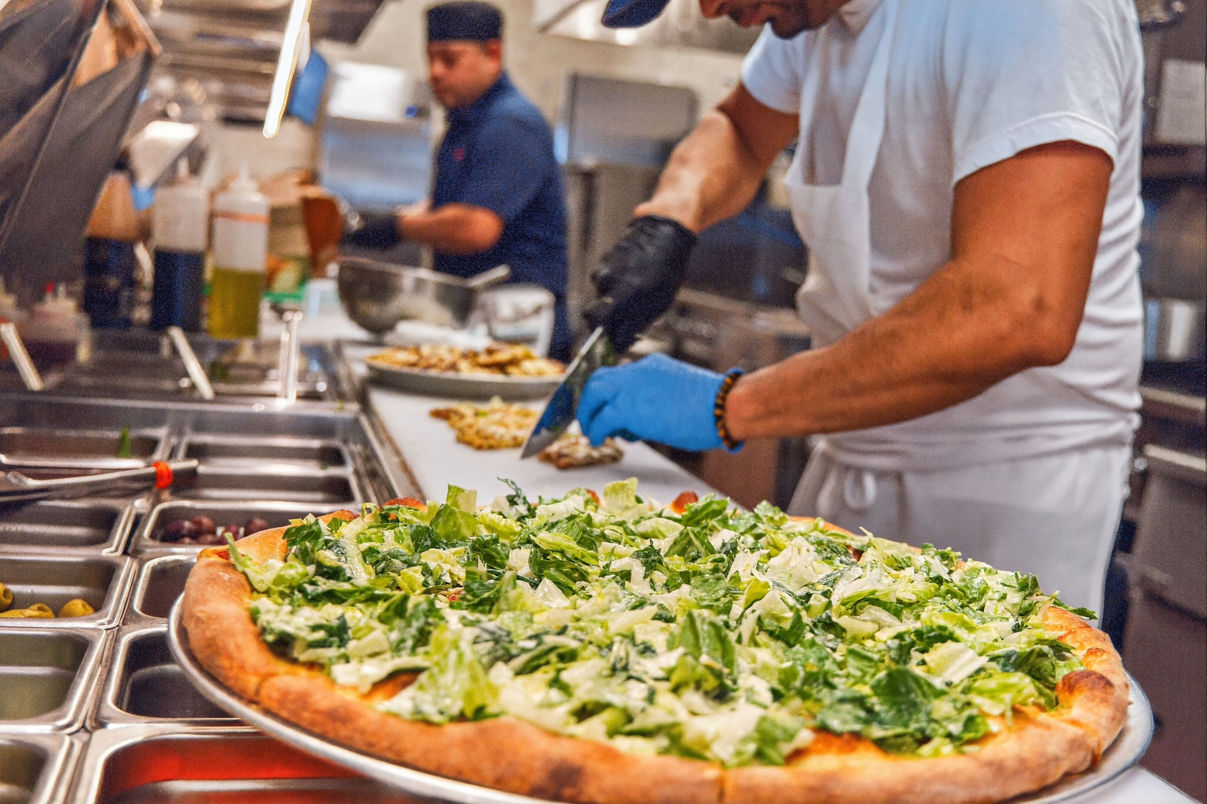 a man cutting a pizza
