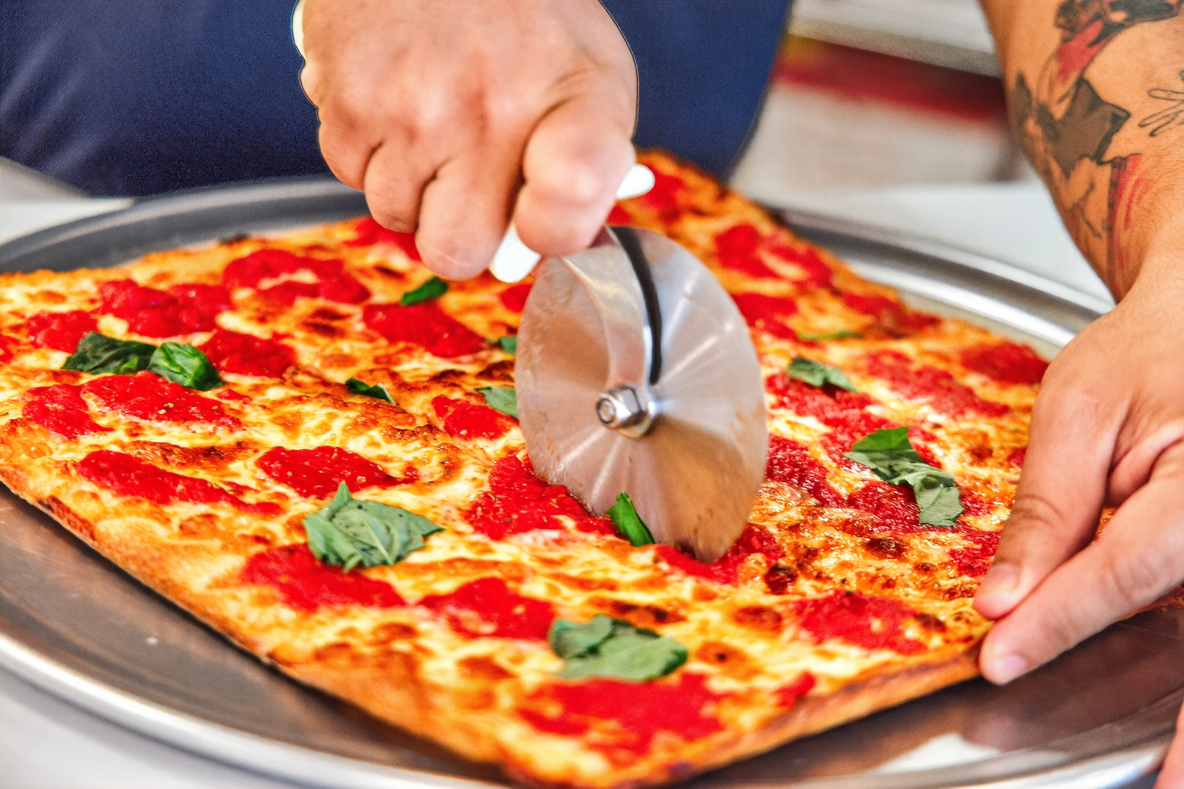 a person cutting a pizza