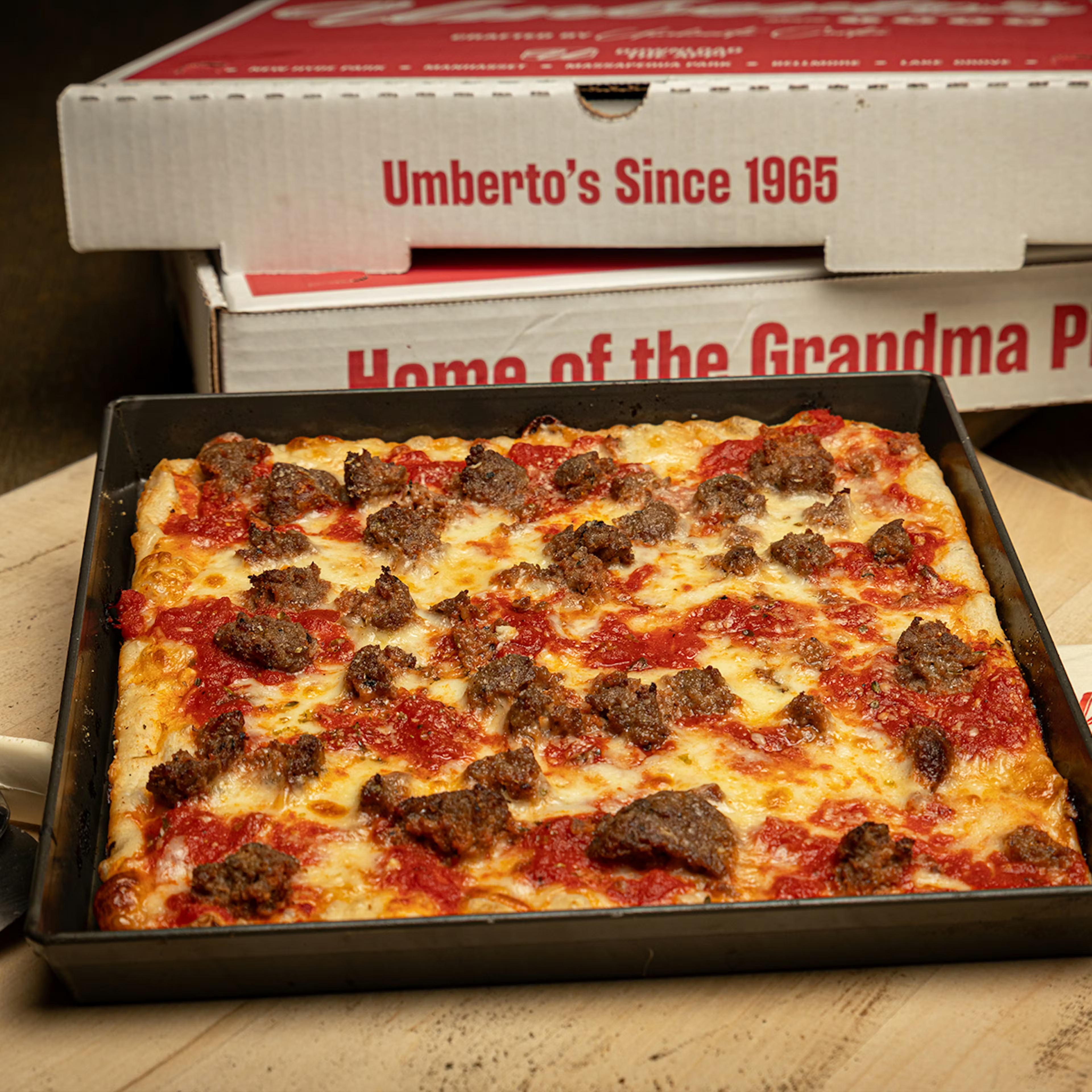 a pizza in a pan next to a pizza box