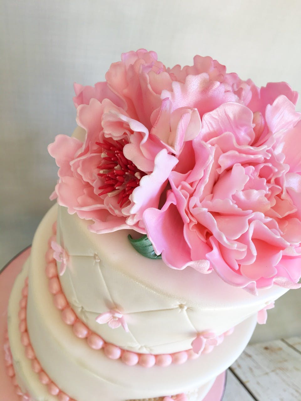 a pink flower sits in a piece of cake on a table