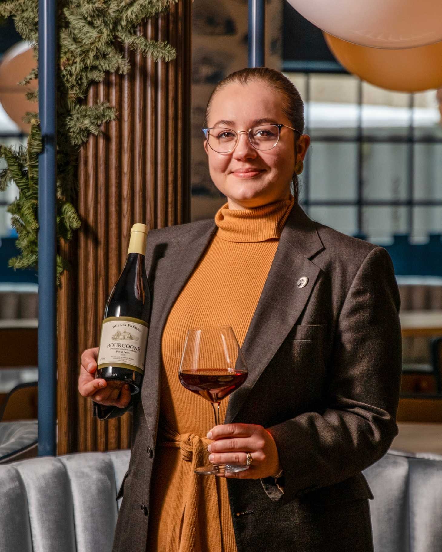 a woman holding a wine glass and a bottle
