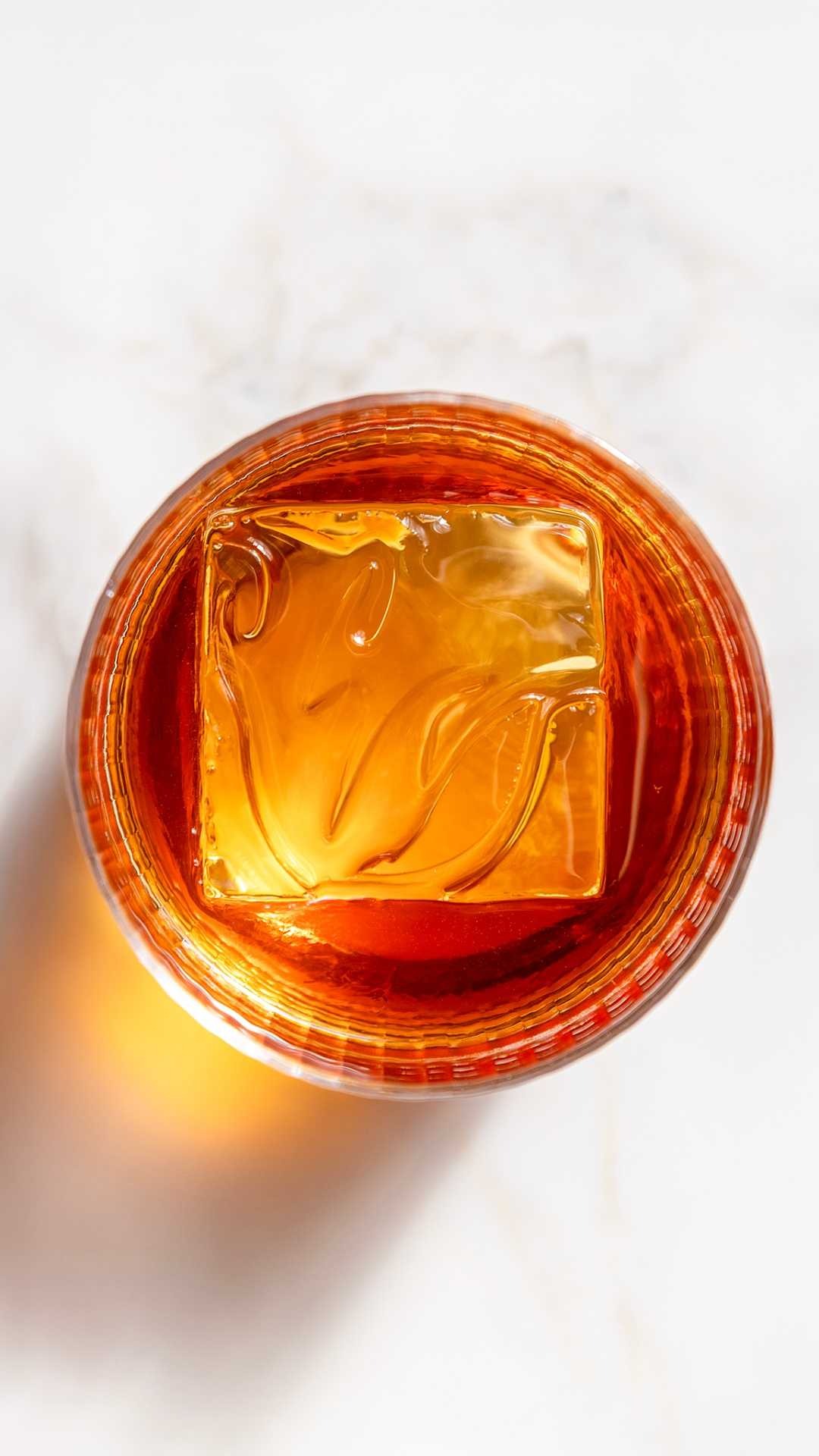 a glass with a drink and ice cube
