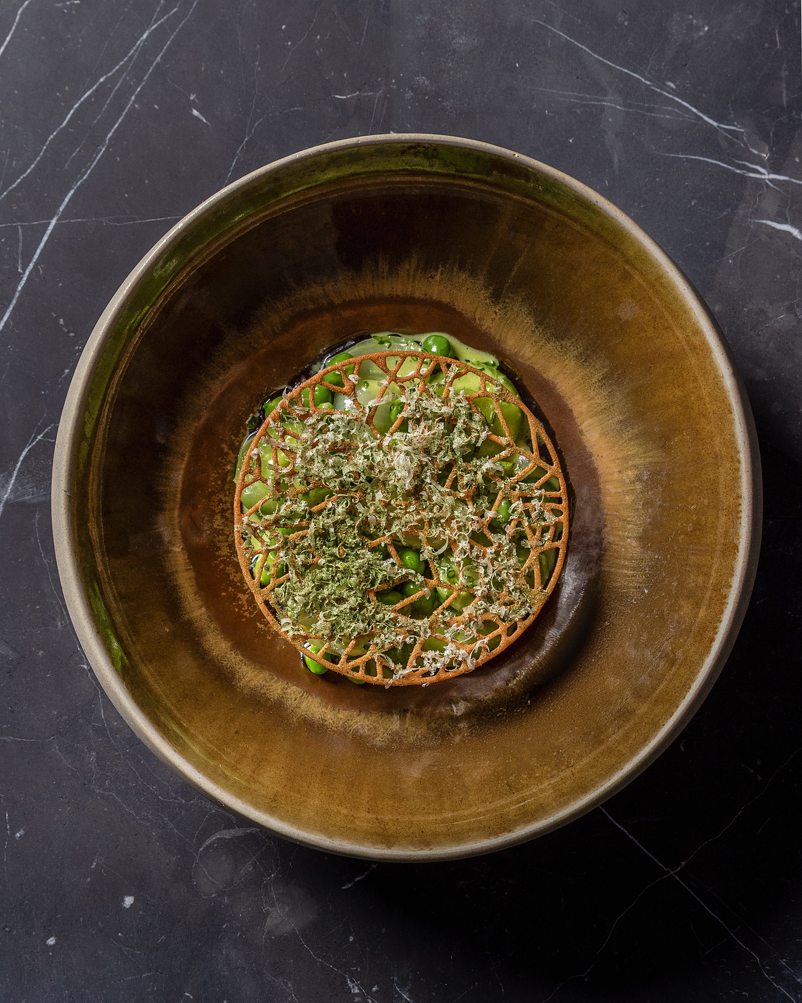 a bowl of pasta on a black marble surface