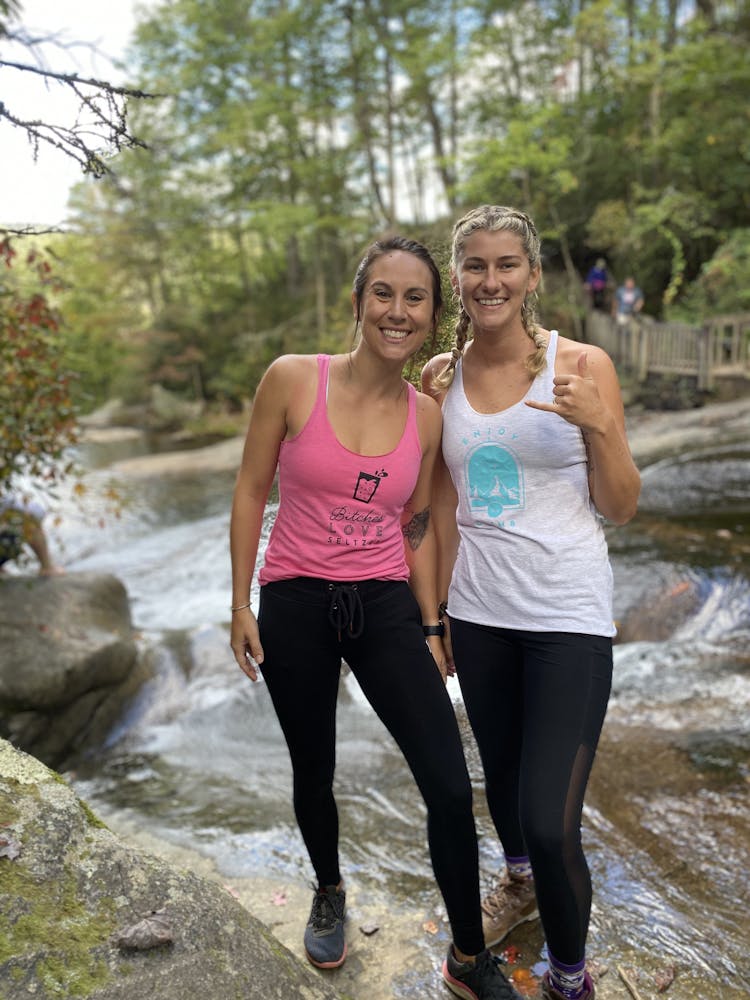 a woman standing next to a body of water
