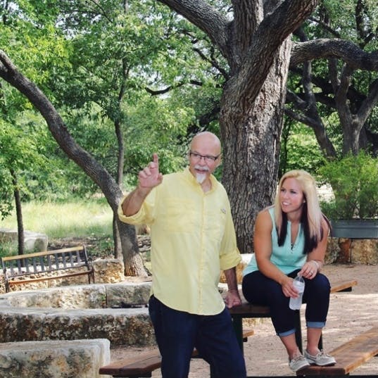 a group of people standing next to a tree